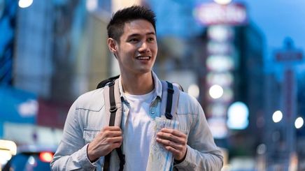 Asian man with a backpack and a map. 