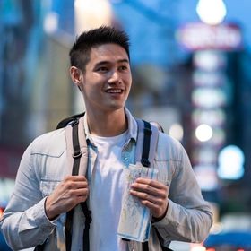 Asian man with a backpack and a map. 