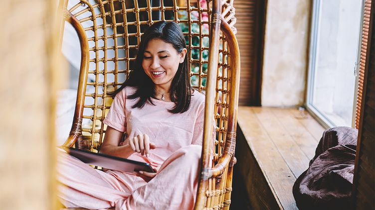 Asian woman sitting in swing looking at notes