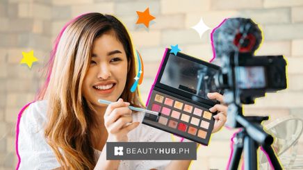 Asian beauty vlogger holding a makeup palette to camera.