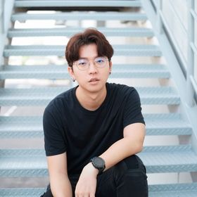 A portrait of man with glasses sitting on the stairs.
