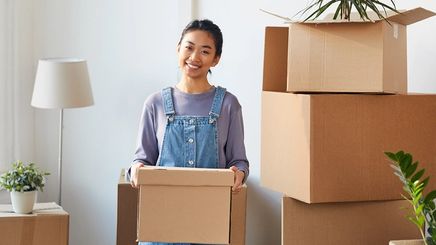 Asian woman holding organizing boxes