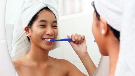 Asian woman brushing her teeth