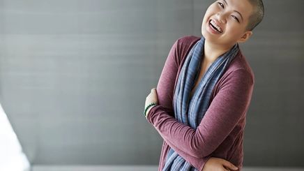 Asian woman with shaved head laughing