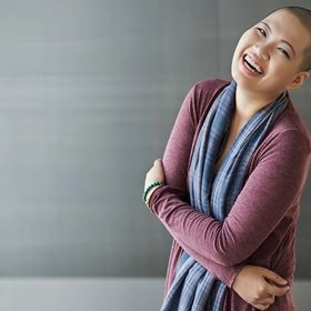 Asian woman with shaved head laughing