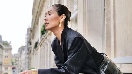 A portrait of Liz Uy with slicked back bun and black outfit.