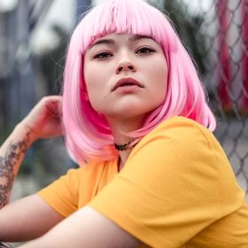 Portrait of an Asian woman with pink hair and tattoos