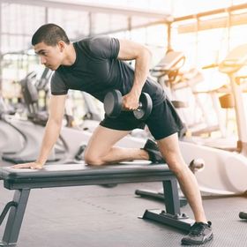 Asian man lifting weights at the gym
