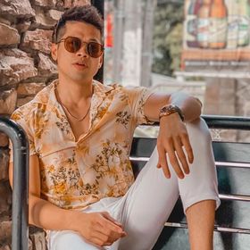 A portrait of Vina Brenica wearing printed shirt and white chinos.