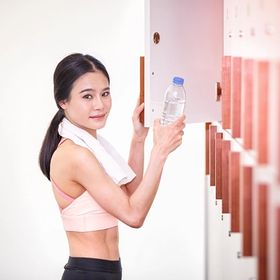 Asian woman putting water in a gym locker room