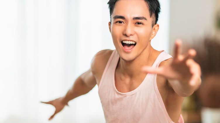 Asian man in sleeveless shirt smiling 