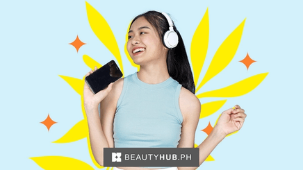 An Asian woman dancing with headphones on