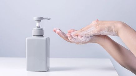 A person washing hands using liquid soap 