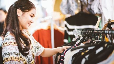 Asian woman browsing at a thrift store. 