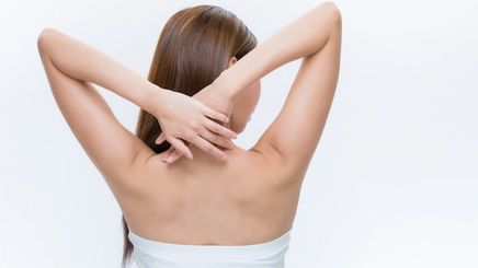Woman with her hands on her nape and back exposed