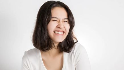 Asian woman with mid-length hair and a big smile