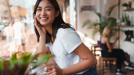 Happy Asian woman at a coffee shop.