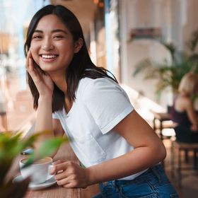 Happy Asian woman at a coffee shop.