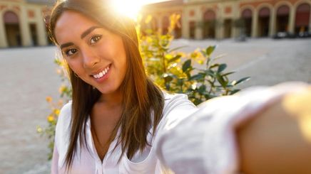 Filipino woman in a white shirt taking a selfie