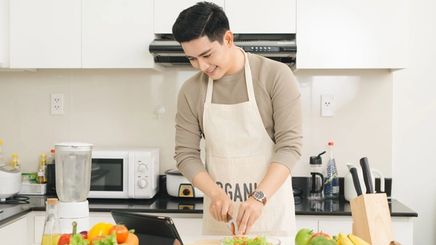 Man in an apron cooking a healthy meal.