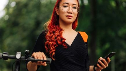 Asian woman with colored hair standing outdoors