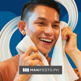 Smiling man wiping face with a towel while looking at the mirror.