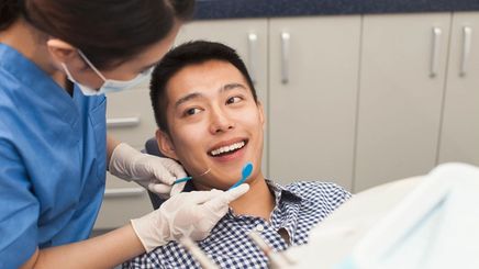 Male patient getting his teeth checked by the dentist.