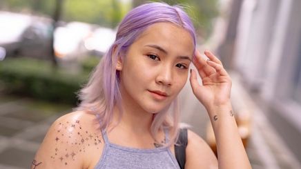 Asian woman with violet hair and tattoos