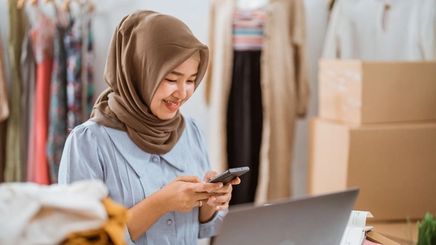 Asian woman in hijab looking at phone