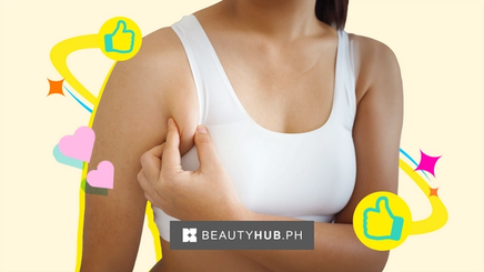 Asian woman in white tank pinching her armpit fat. 