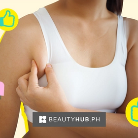 Asian woman in white tank pinching her armpit fat. 