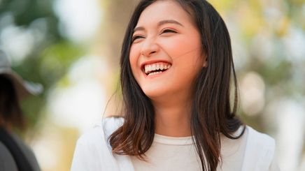 Pretty Asian girl laughing with hair down.