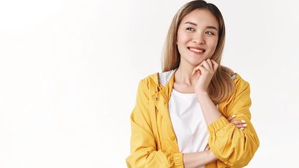 Young Asian woman with blonde hair wearing a yellow windbreaker