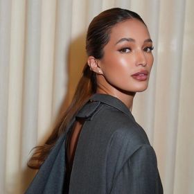 A portrait of Sarah Lahbati with a low ponytail.