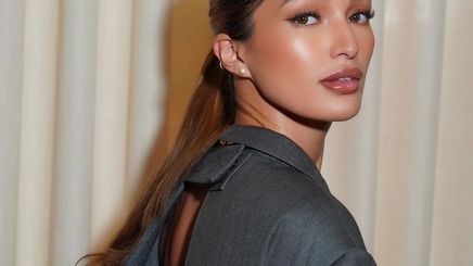 A portrait of Sarah Lahbati with a low ponytail.
