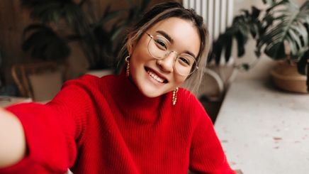 Woman in red sweater smiling and glowing