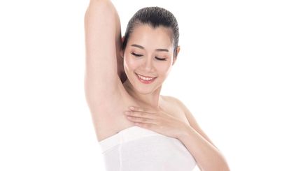 Asian woman looking at her armpits 
