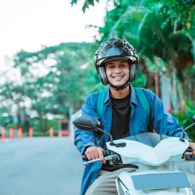 Asian man wearing helmet on a bike.