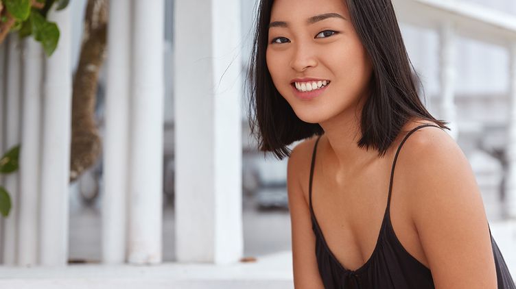 Asian woman with brown skin smiling