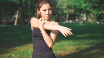 Asian woman stretching in workout clothes