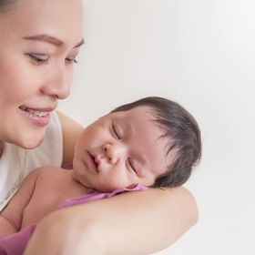 Asian mom cradling baby 
