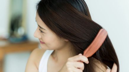 Woman brushing her hair with a comb.