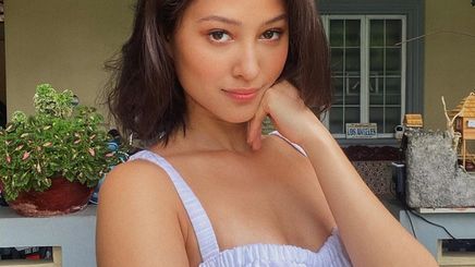 Maureen Wroblewitz in a white top posing with her hand below her chin.