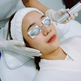 Woman getting a laser facial treatment at a clinic.