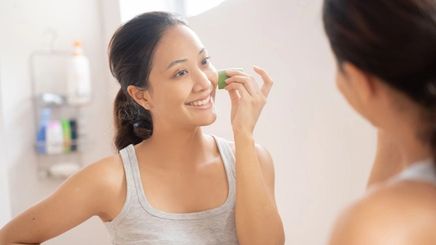 Asian woman applying aloe vera on her skin