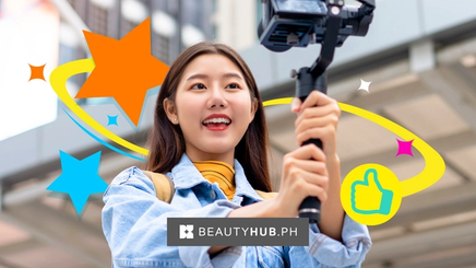 Asian woman smiling in front of a camera with a selfie stick.