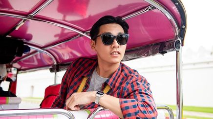 Asian man wearing sunglasses riding public transportation