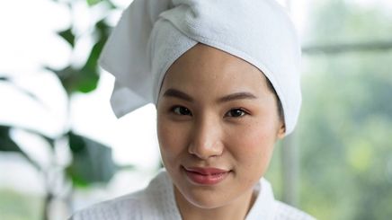 Asian woman wearing a spa robe and hair towel