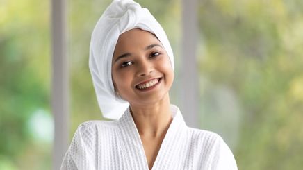 A woman wearing a towel on her head and robe.