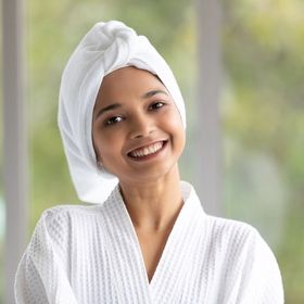 A woman wearing a towel on her head and robe.